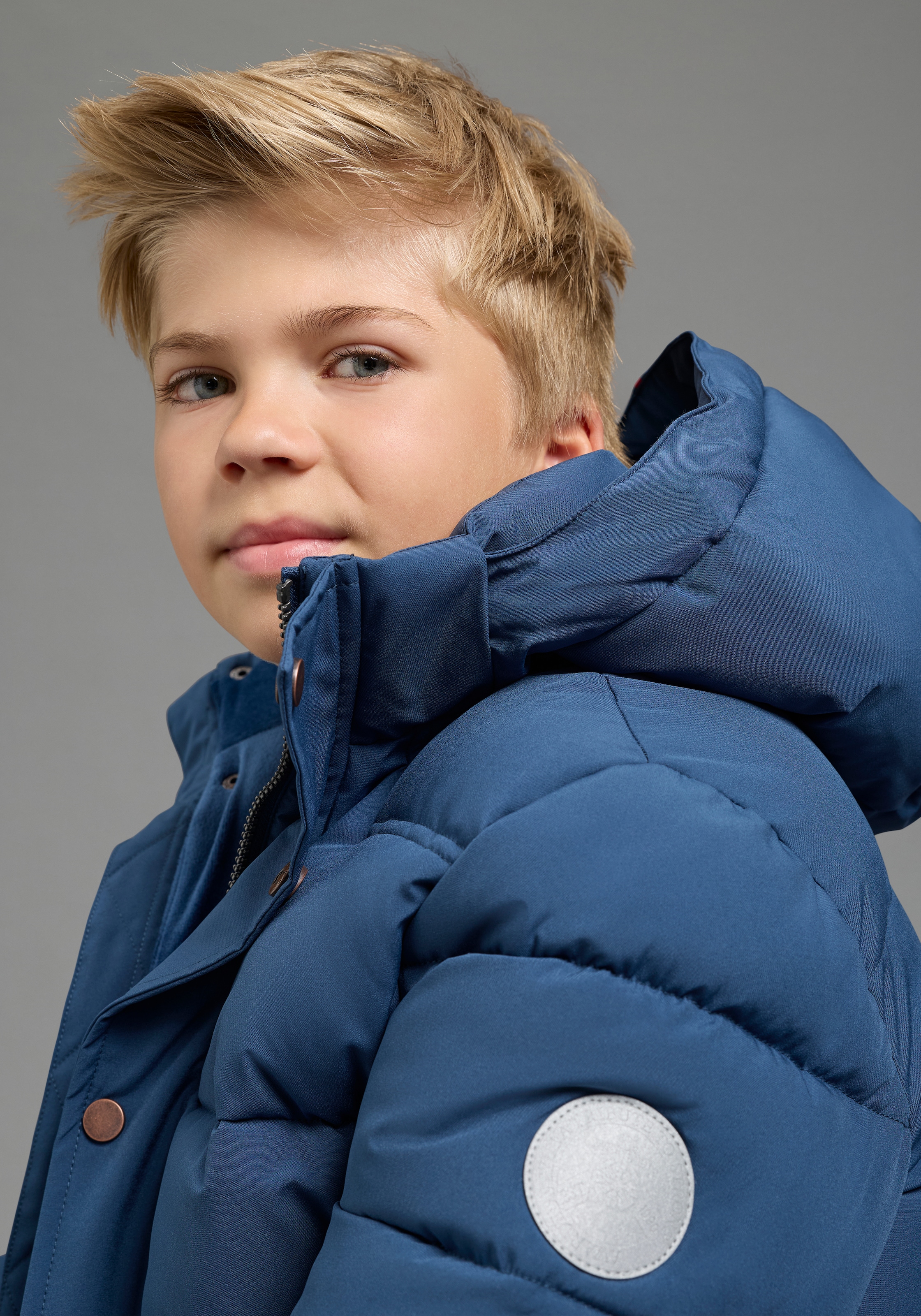 KIDSWORLD Outdoorjacke »Winterwarme Jacke, gesteppt« mit Kapuze Trendige Winterjacke mit refklektierenden Details