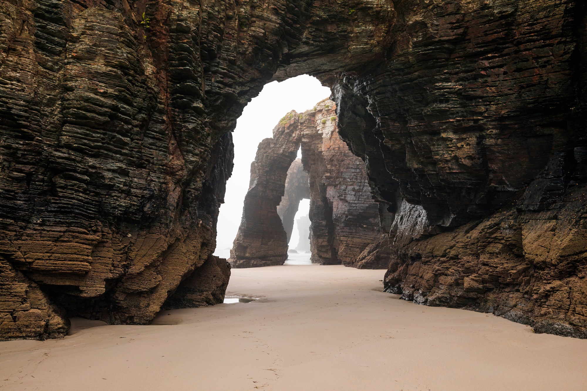Papermoon Fototapete »GROTTE-FELSEN EBBE SPANIEN TUNNEL STRAND DUNEN MEER«