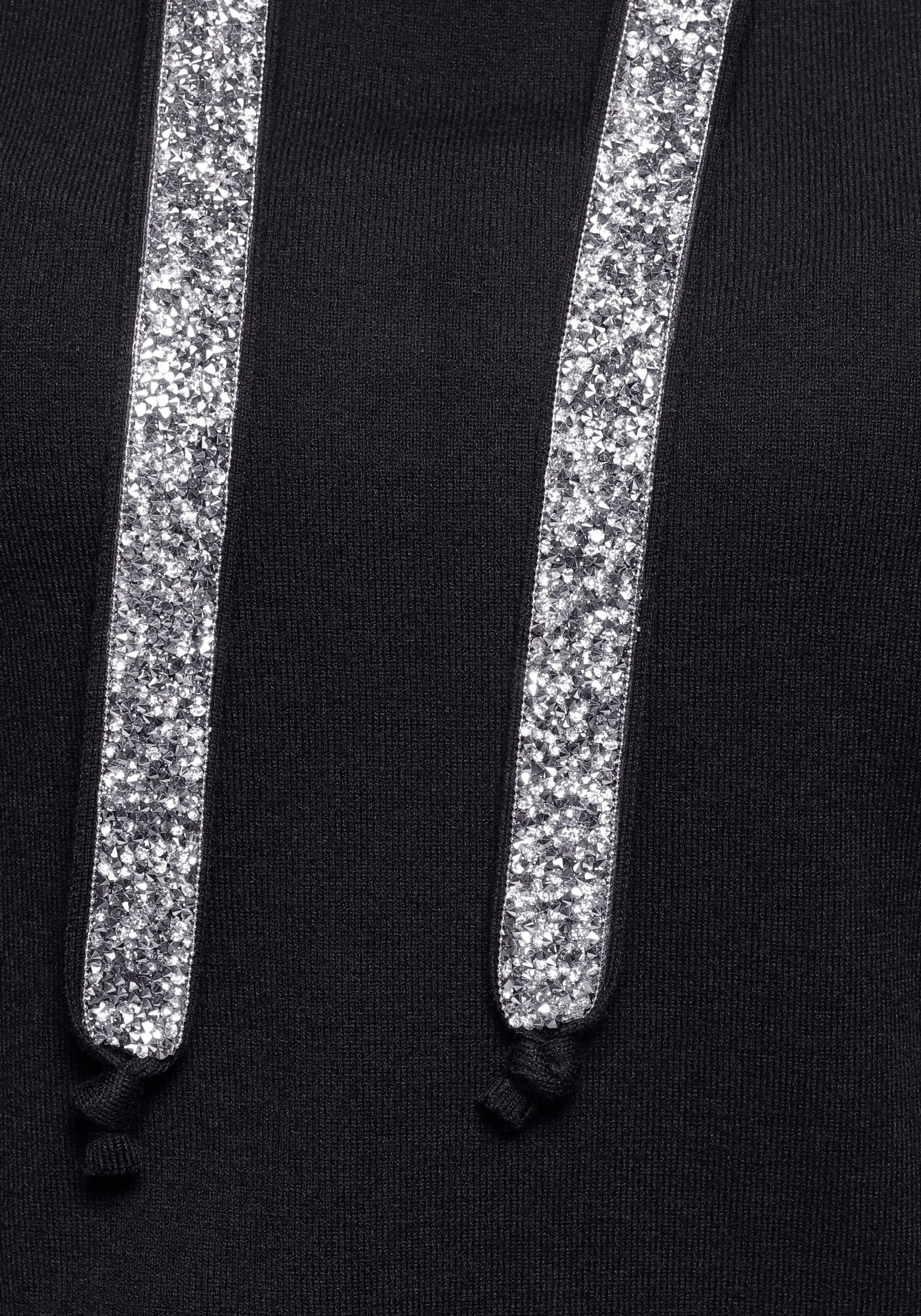 Laura Scott mit Kapuze und glitzernden Bändern