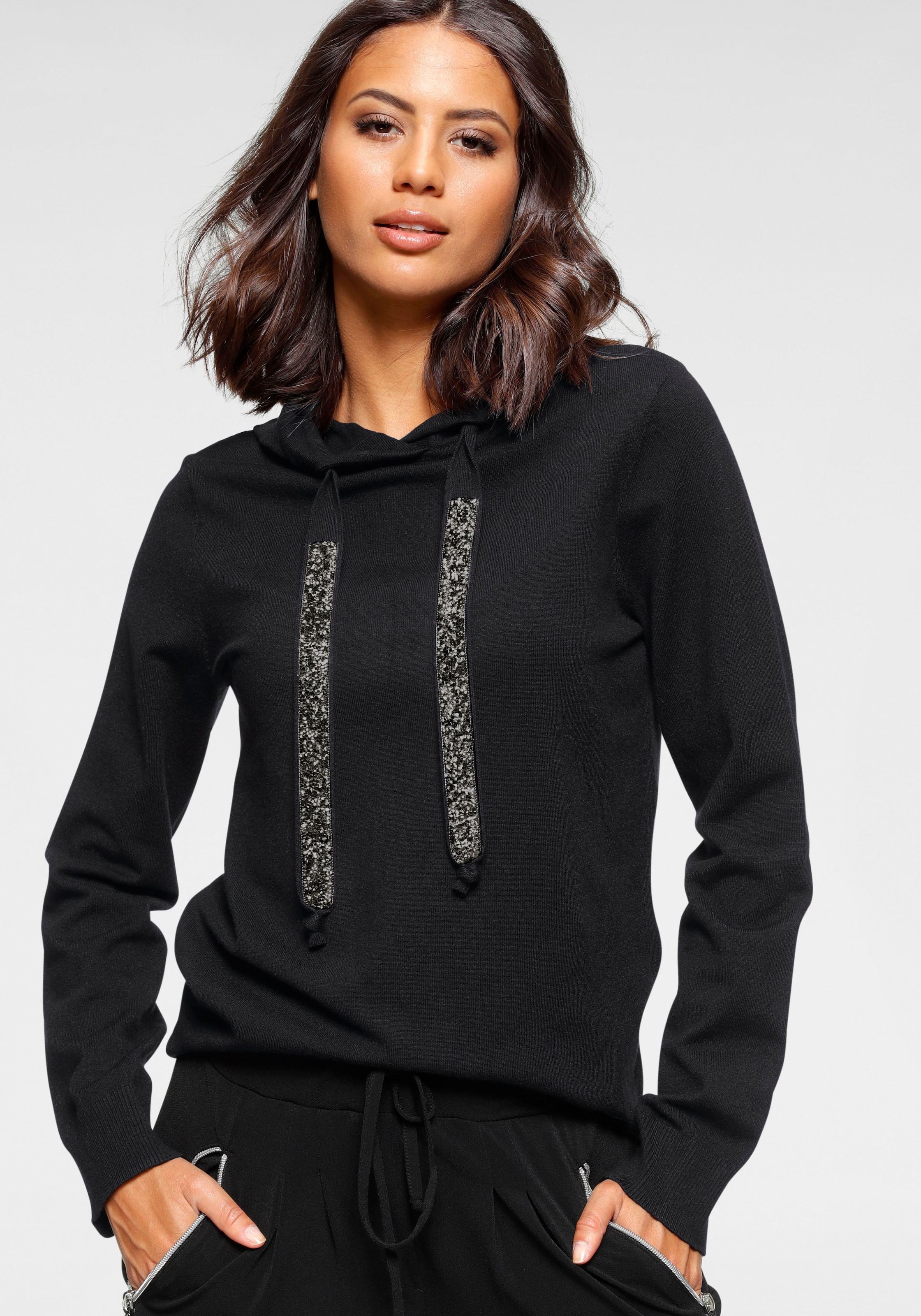 Laura Scott mit Kapuze und glitzernden Bändern