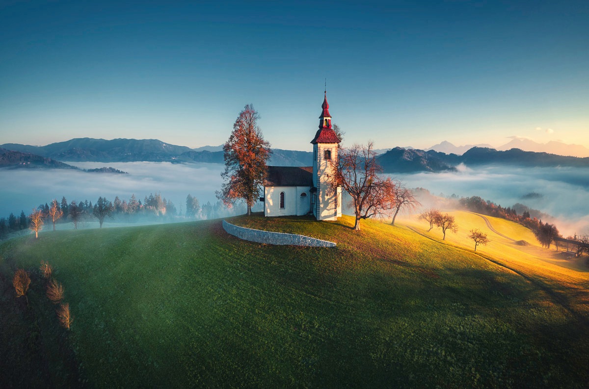 Image of Papermoon Fototapete »PANORAMA-KIRCHE SONNE GEBIRGE LANDSCHAFT SLOWENIEN XXL«, Vliestapete, hochwertiger Digitaldruck, inklusive Kleister bei Ackermann Versand Schweiz